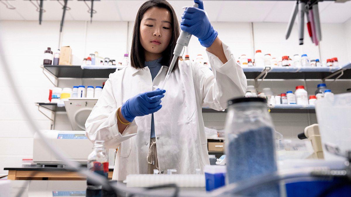 A student transfers liquid from a syringe into a vial.