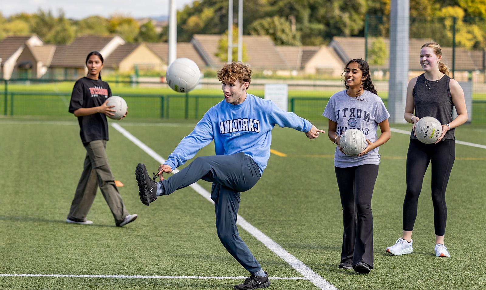 A student kicking a ball.